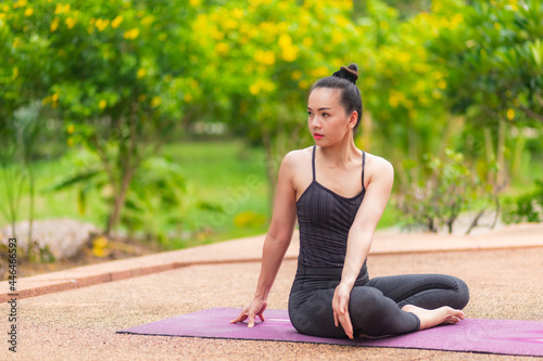 Close-up of a beautiful woman practicing yoga in a natural outdoor garden for relaxation and health care. © atsarapong