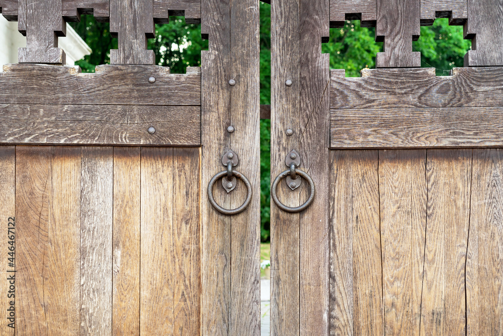 Old wooden gate with round forged handles. Old wooden gate with round forged handles.