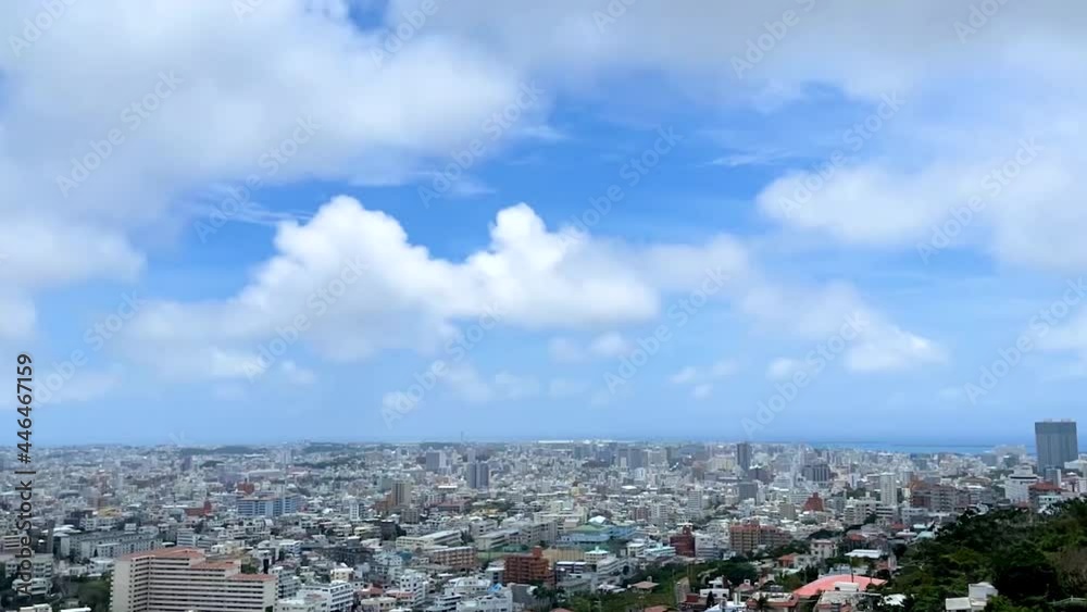 NAHA, OKINAWA, JAPAN -JUN 2021 : Aerial high angle wide view of Naha city in daytime. Sunny summer blue sky and clouds. Cityscape of downtown area. Time lapse tracking shot. Holiday and travel concept NAHA, OKINAWA, JAPAN -JUN 2021 : Aerial high angle wide view of Naha city in daytime. Sunny summer blue sky and clouds. Cityscape of downtown area. Time lapse tracking shot. Holiday and travel concept