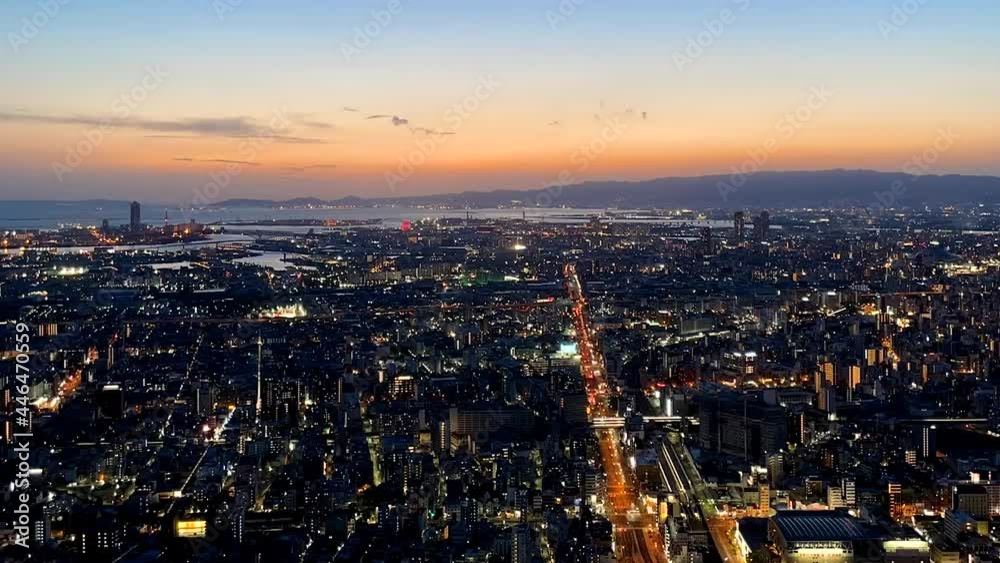 OSAKA, JAPAN : Aerial high angle sunrise view of CITYSCAPE of OSAKA. View of buildings and street traffic around Osaka bay and Kobe port. Long time lapse wide view tracking shot, night to morning. OSAKA, JAPAN : Aerial high angle sunrise view of CITYSCAPE of OSAKA. View of buildings and street traffic around Osaka bay and Kobe port. Long time lapse wide view tracking shot, night to morning.