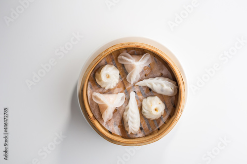 Chinese dim sum dumplings in bamboo basket isolated on white background