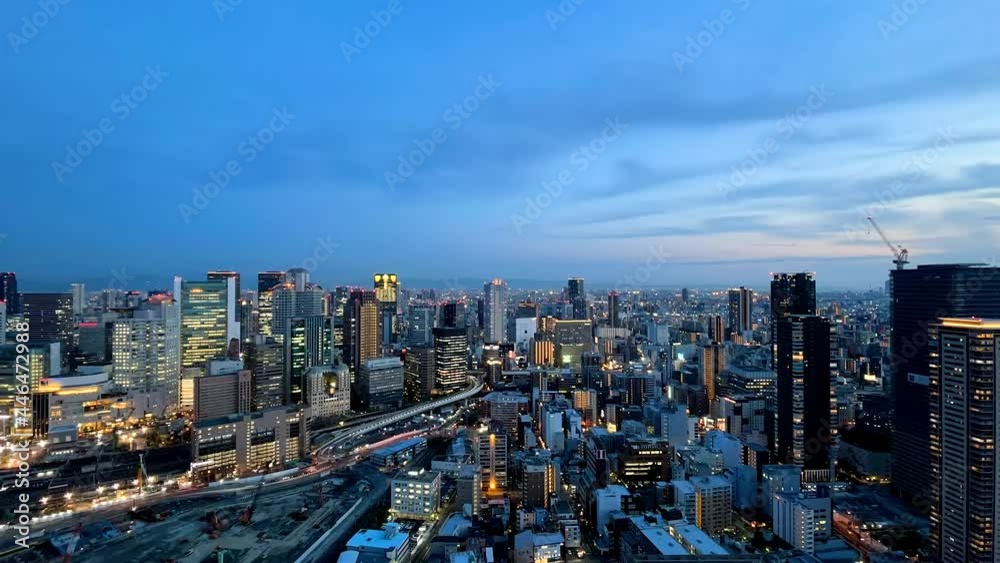 UMEDA, OSAKA, JAPAN : Aerial high angle sunset view of CITYSCAPE of OSAKA. View of buildings and street around Osaka and Umeda station. Wide view time lapse zoom out shot, dusk to night. UMEDA, OSAKA, JAPAN : Aerial high angle sunset view of CITYSCAPE of OSAKA. View of buildings and street around Osaka and Umeda station. Wide view time lapse zoom out shot, dusk to night.