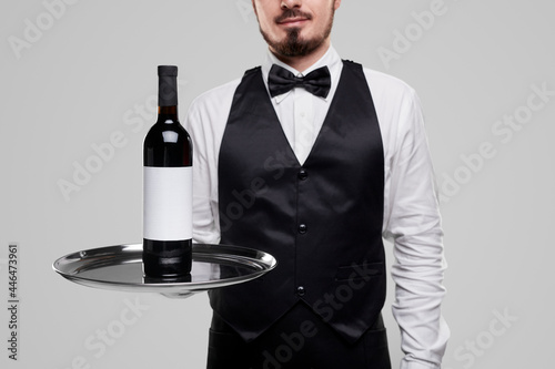 Elegant waiter serving bottle of wine © kegfire