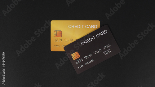 Black and gold credit card isolated on black background.