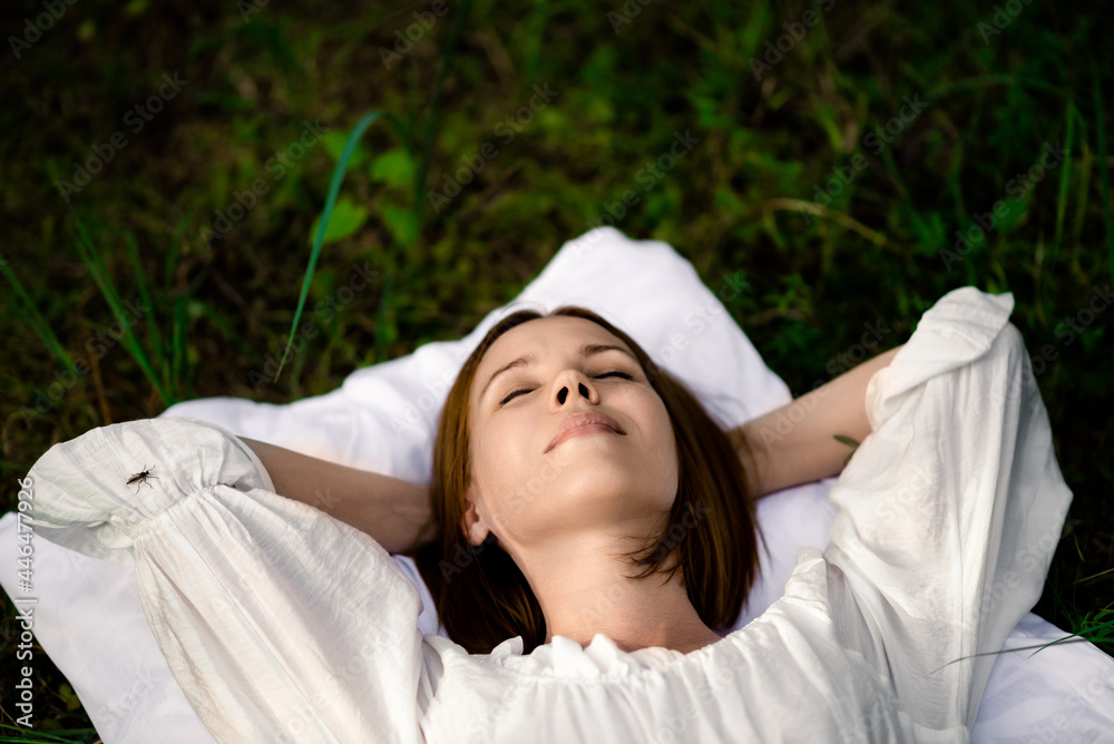 Healthy sound sleep. Rest, relaxation in the forest. Woman sleeps on a pillow on a green glade in the forest. Healthy sound sleep. Rest, relaxation in the forest. Woman sleeps on a pillow on a green glade in the forest.