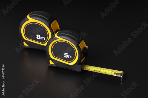 Flexometers or measuring tapes on black background photo