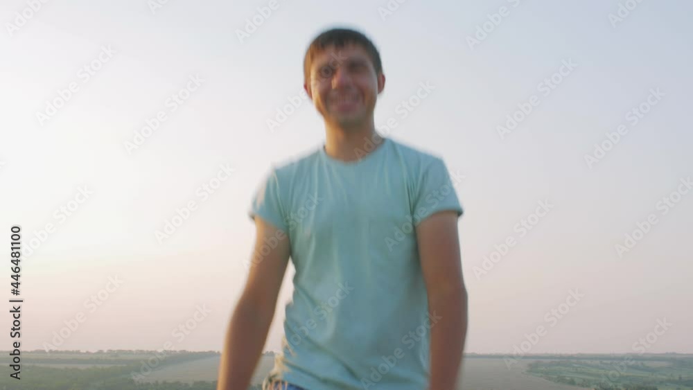 man in cheerful mood throwing paper airplane in field on sunset on background of clear sky, concept of active rest outdoors and relaxation, toy of childhood man in cheerful mood throwing paper airplane in field on sunset on background of clear sky, concept of active rest outdoors and relaxation, toy of childhood