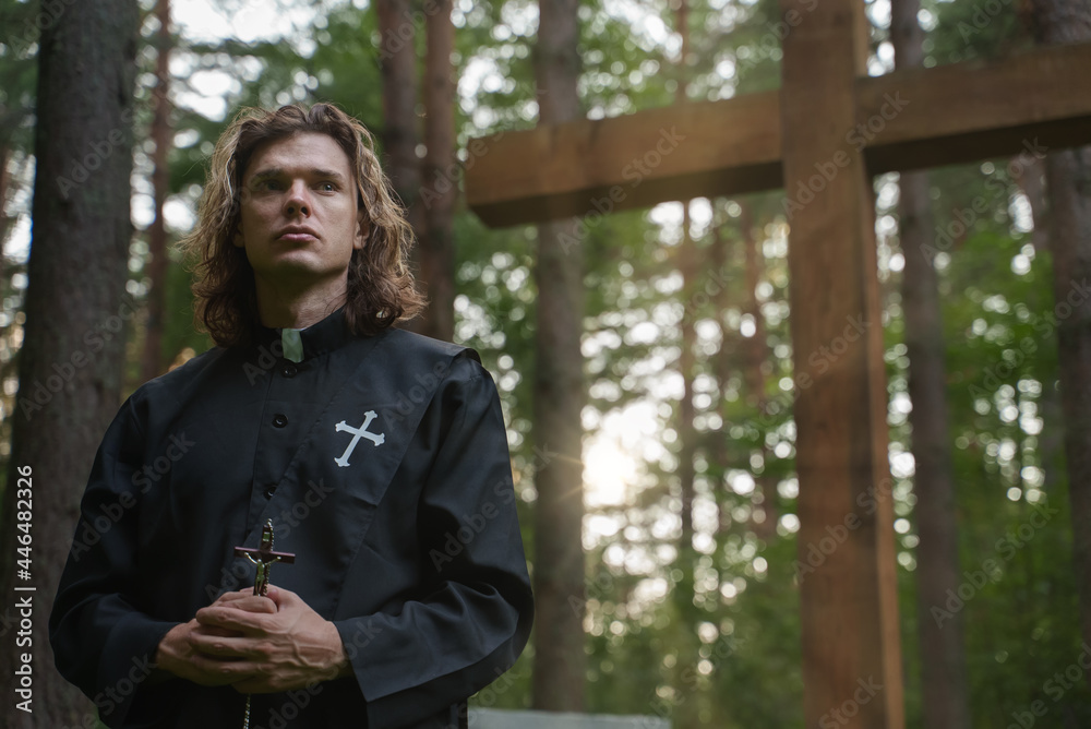 Christian priest with cross on the cemetery. Christian priest with cross on the cemetery.