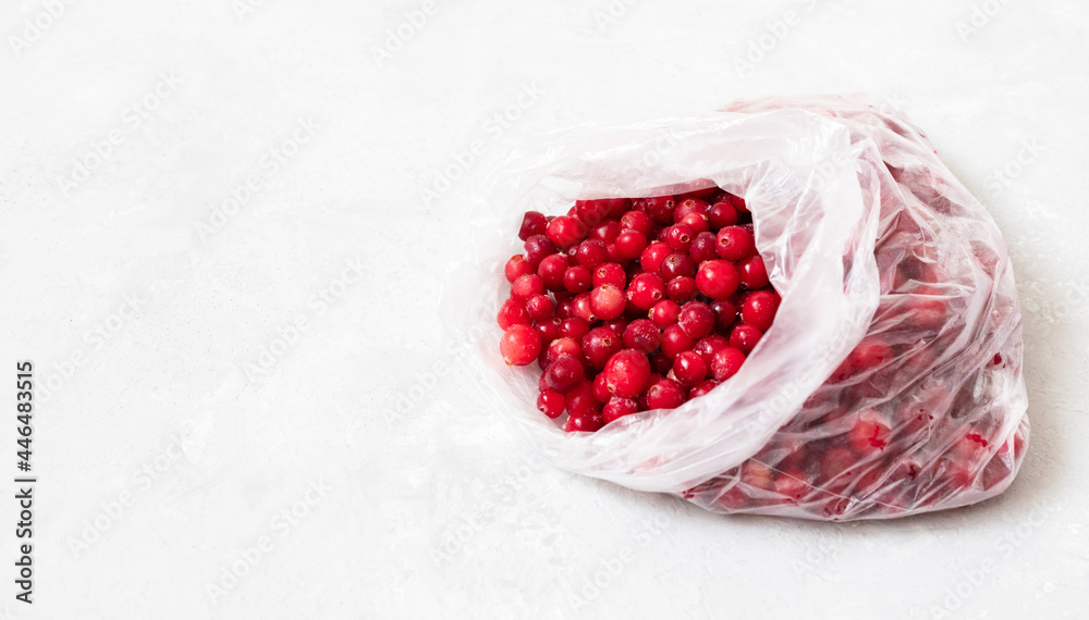 Frozen cranberries in a package closeup. Frozen berries on a white background. Homemade preparations. Copy space. Frozen cranberries in a package closeup. Frozen berries on a white background. Homemade preparations. Copy space.