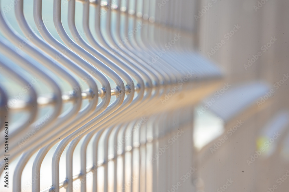 Elements of a metal vertical fence, large, with a strong background blur, a territory free of COVID-19 Elements of a metal vertical fence, large, with a strong background blur, a territory free of COVID-19