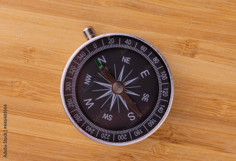 Classic round compass on a wooden background. Travel concept. View from above.