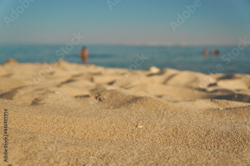 Calm  beach on the sea in summer with golden yellow  sand and a few people in the background © Julia Snow
