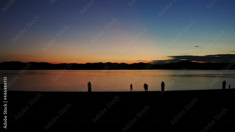 Sunset over the mountain range. Calm sea in calm, shining reflections Sunset over the mountain range. Calm sea in calm, shining reflections