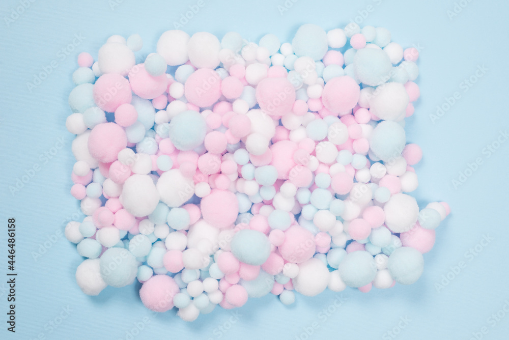 White, pink and blue soft pompons as a background. White, pink and blue soft pompons as a background.