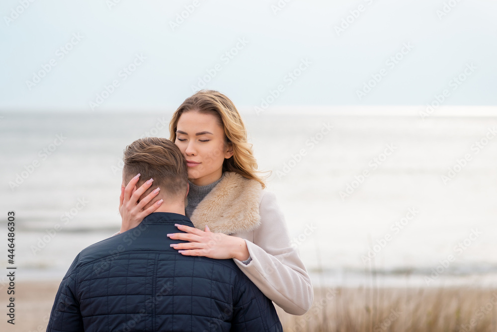 young beautiful stylish couple in spring on the beach. Hug each other and enjoy a warm spring evening.Close up. young beautiful stylish couple in spring on the beach. Hug each other and enjoy a warm spring evening.Close up.
