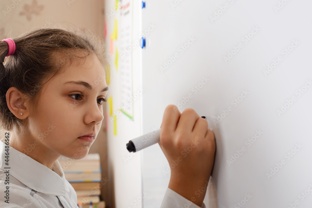 Little girl writing something on board while conducting the home assignment. Education in the classroom Little girl writing something on board while conducting the home assignment. Education in the classroom