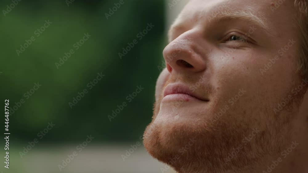 Portrait of Face Handsome Redhead bearded Man with Freckles looking up. Having Beautiful Green Eyes, standing in Park while Rain Dripping on Face. Feeling Pleasure with Nature. Caucasian Appearance. Portrait of Face Handsome Redhead bearded Man with Freckles looking up. Having Beautiful Green Eyes, standing in Park while Rain Dripping on Face. Feeling Pleasure with Nature. Caucasian Appearance.
