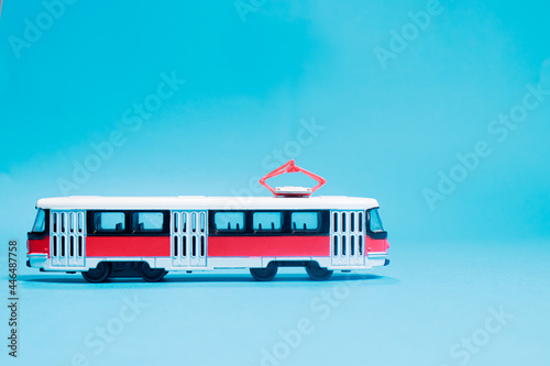 Children's toy red white tram on a blue background copy space for text. Toys for a toy store, cars for a boy.
