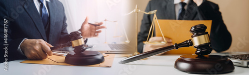 Business and lawyers discussing contract papers with brass scale on desk in office. Law, legal services, advice, justice and law concept photo