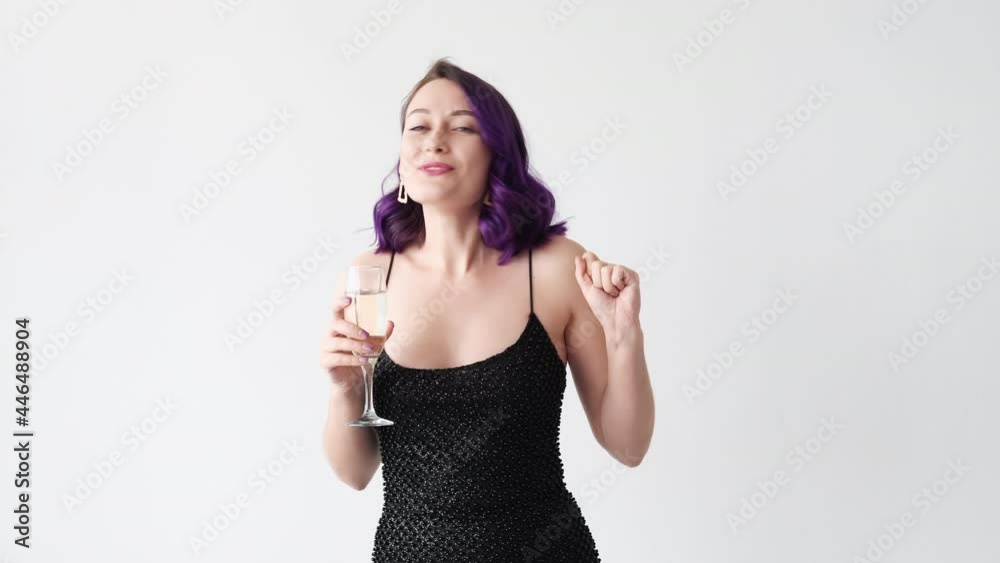 Birthday greeting. Happy woman. Festive toast. Party celebration. Cheerful pretty lady black dress purple curly hair congratulating sending blow kiss with glass of champagne isolated white. Birthday greeting. Happy woman. Festive toast. Party celebration. Cheerful pretty lady black dress purple curly hair congratulating sending blow kiss with glass of champagne isolated white.
