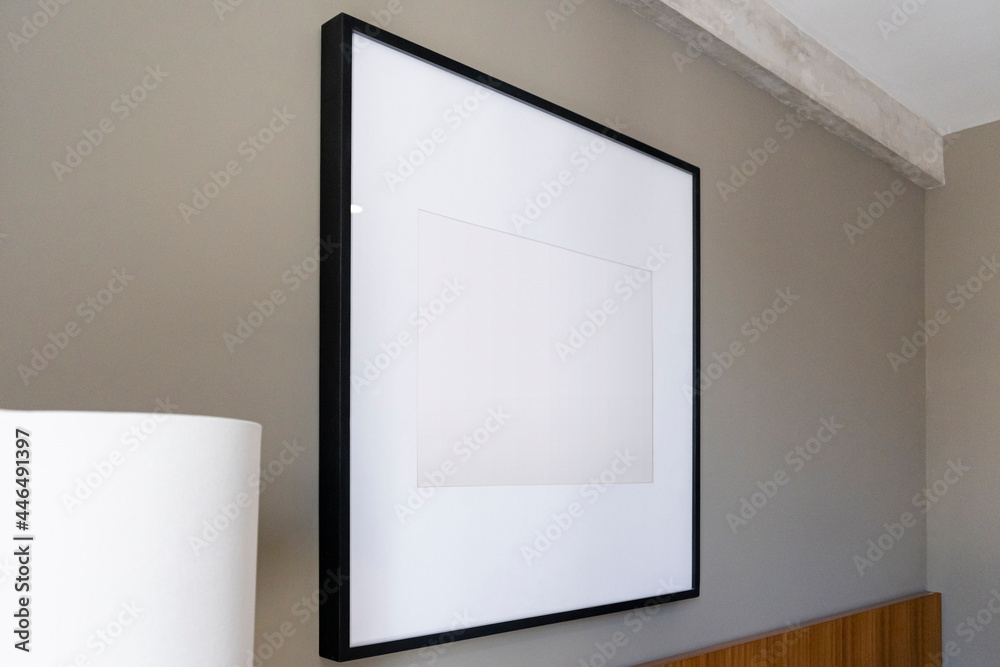 Modern house decoration, empty black square frame, poster, white canvas, mock up, on a gray wall, bedroom, template low angle view Modern house decoration, empty black square frame, poster, white canvas, mock up, on a gray wall, bedroom, template low angle view