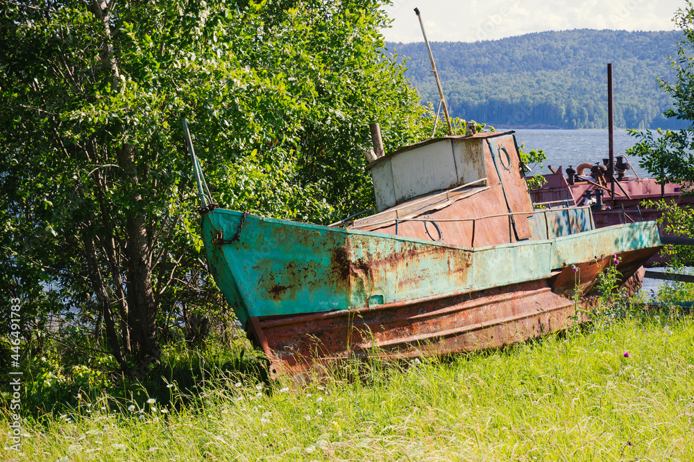 Rusty metal abandoned boat was left on the river shore Rusty metal abandoned boat was left on the river shore