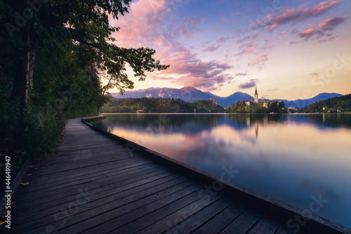 Slika na platnu Wooden promenade near lake in mountains at sunset