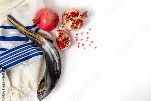 Talit, shofar, pomegranate and pomegranate seeds, on white background, top view. Rosh hashana photo