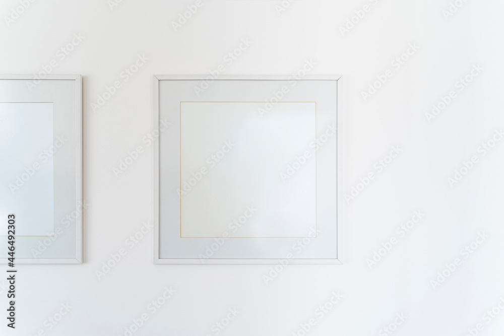 Empty square white frame, poster white canvas mock up on a white wall, living room, template front view, home decoration Empty square white frame, poster white canvas mock up on a white wall, living room, template front view, home decoration