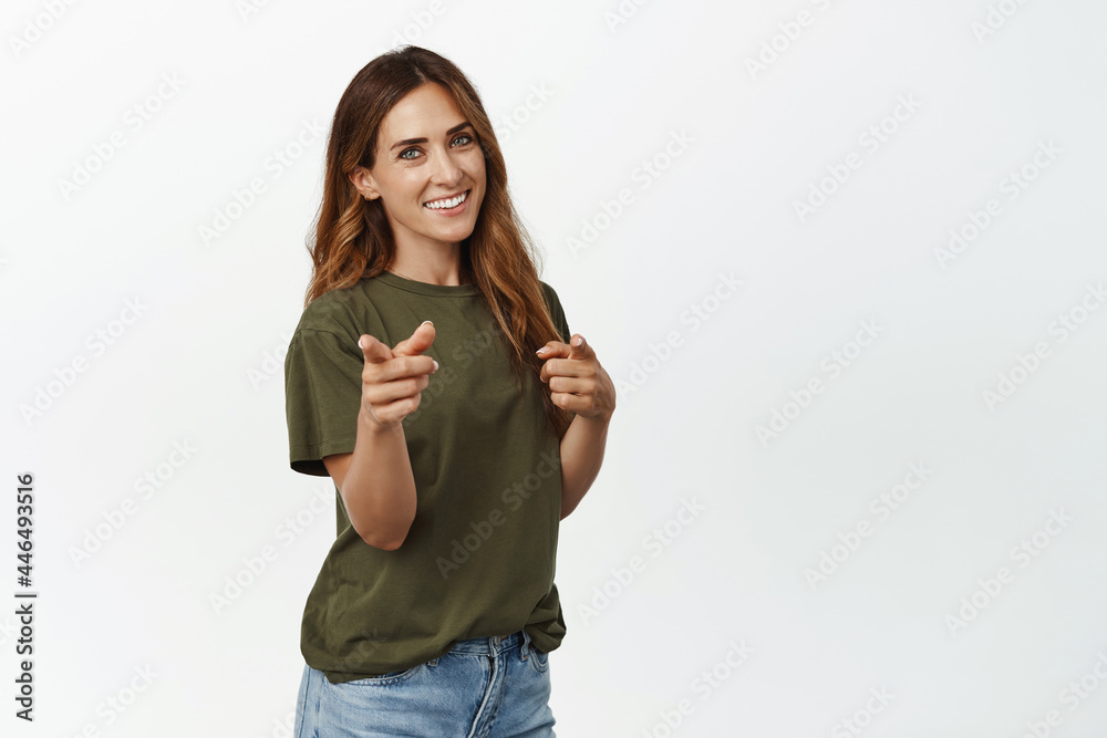 Its you congrats. Smiling adult woman pointing fingers at camera, congratulating, picking a winner, inviting people to sale, recruiting, standing against white background Its you congrats. Smiling adult woman pointing fingers at camera, congratulating, picking a winner, inviting people to sale, recruiting, standing against white background