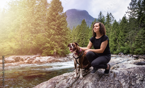 White Caucasian Adult Woman hiking with Boxer Dog in the Canadian Nature. Golden Ears Provincial Park, Maple Ridge, Greater Vancouver, British Columbia, Canada. photo