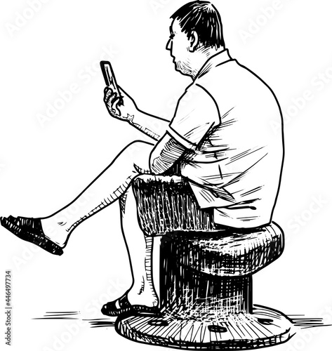 Sketch of city dweller sitting on bollard on city embankment and looking at his smartphone