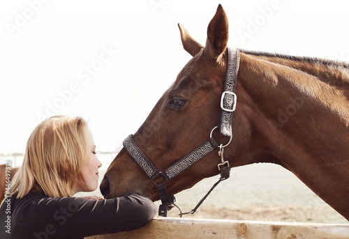 Girl kissing a horse - rural scene in soft colors