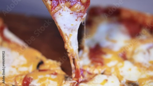 Hot Pizza close-up. Hand takes a slice of hot pizza.
