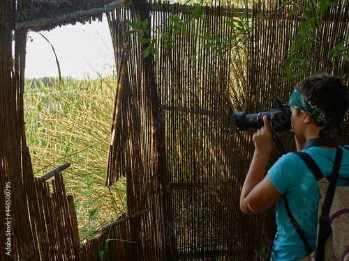 Caucasian girl photographing plant during forest excursion