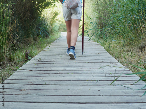 Caucasian girl feet on field trip on wooden path