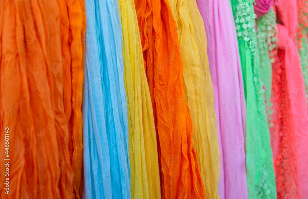 Background of many colorful pashmina scarves hanging