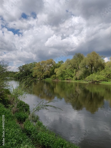 spring tranquil landscape with river  sky  clouds and reflection