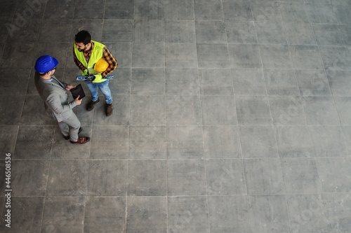 Aerial view of architect and construction worker standing on site and discussing about project. © dusanpetkovic1