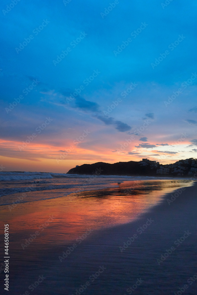 Sunset on the beach with the reflection of the red sky in the water, mexican pacific, acapulco diamante