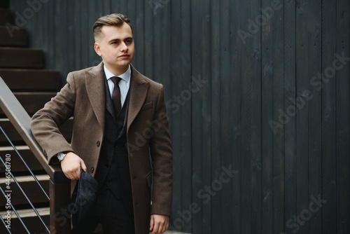 A man walks at city street in the image of an English retro gangster of the 1920s dressed in Peaky blinders style. photo