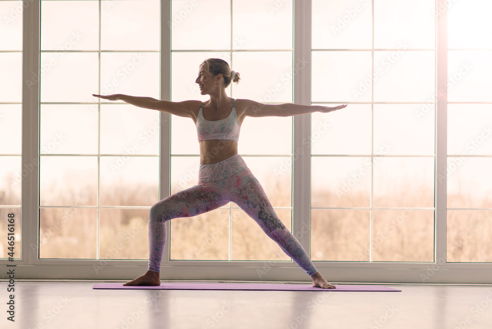 Fototapeta premium Health concept. Young beautiful woman does yoga exercise in the modern room