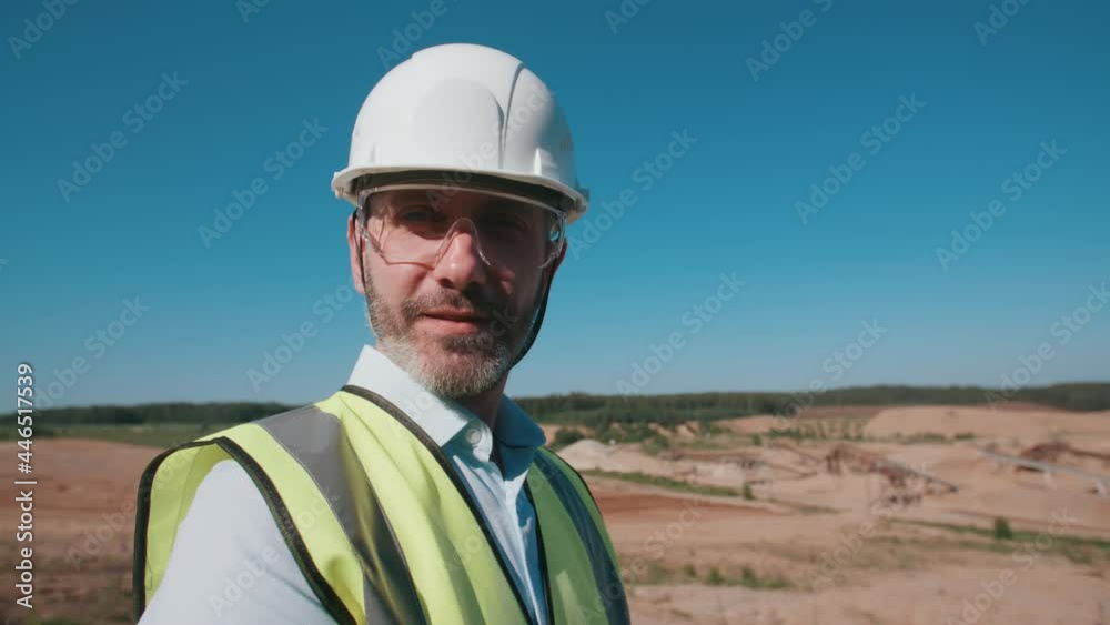 Portrait happy sand quarry worker engineer, male caucasian foreman in safety wear and hardhat looking at camera and smiling. Positive industrial worker, mining project specialist on sunny day Portrait happy sand quarry worker engineer, male caucasian foreman in safety wear and hardhat looking at camera and smiling. Positive industrial worker, mining project specialist on sunny day