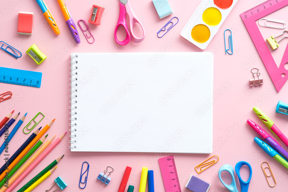 School supplies and paper notepad on pink background. Back to school concept. Flat lay, top view, copy space.