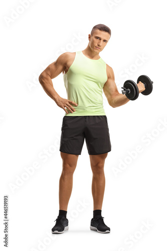 Full length portrait of a serious young man in sportswear exercising with a dumbbell