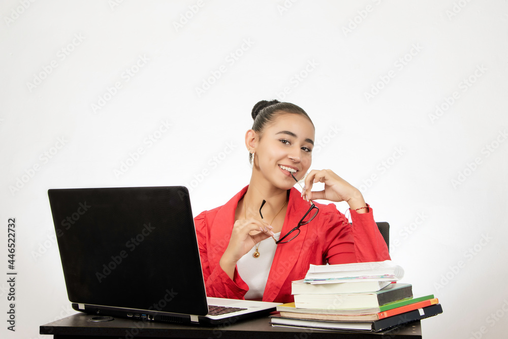 young woman sitting in front of a computer with glasses and books young woman sitting in front of a computer with glasses and books