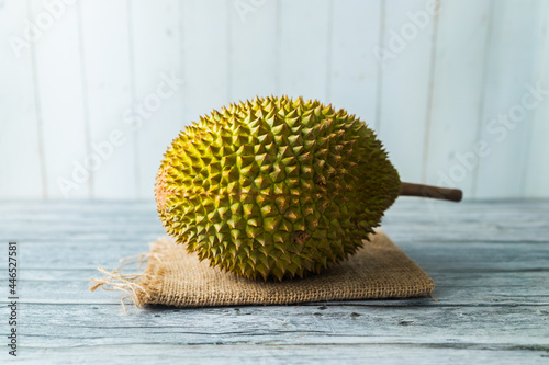 Durian on a brown cloth on top of a wood table