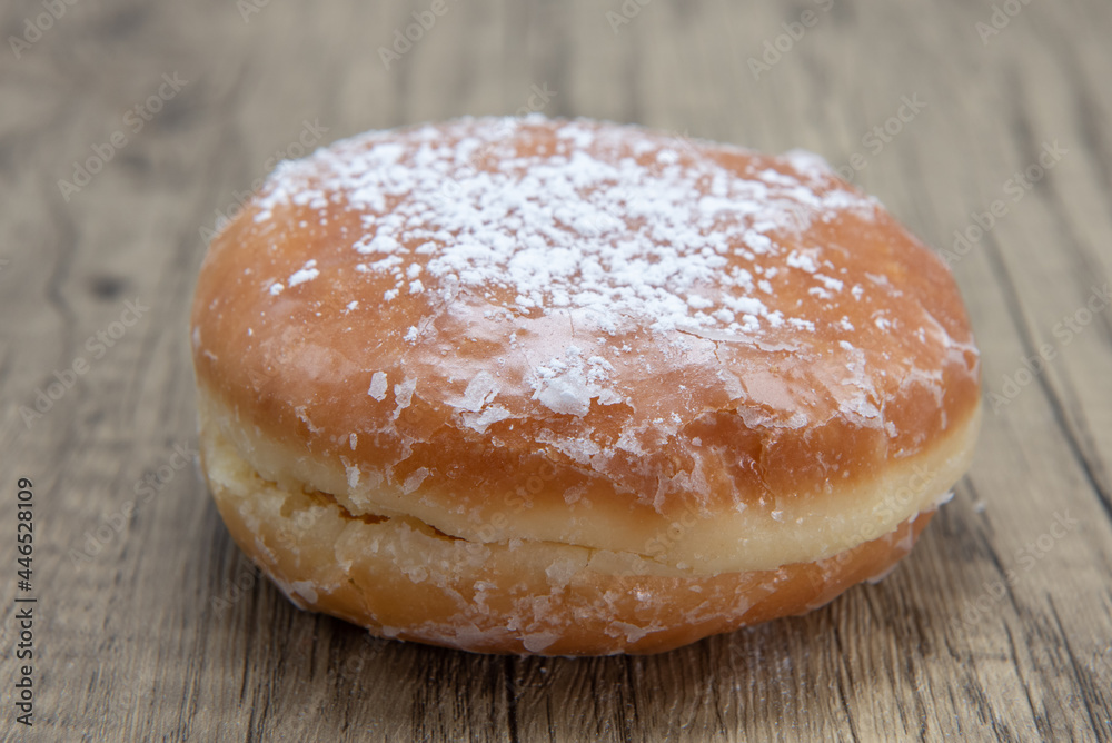 Lemon filled glazed donut is textured with powdered sugar coating for a sweet treat delight