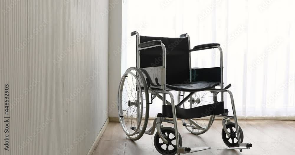 Zoom in technic video, wheelchair with nobody in the room with a white curtain in the background. Disable people and health care concept.