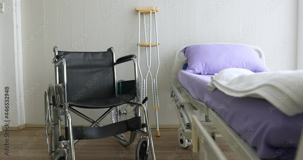Wide zoom out technic video, wheelchair and crutches, walking aids and patient bed with nobody in the room. Disable people and health care concept.